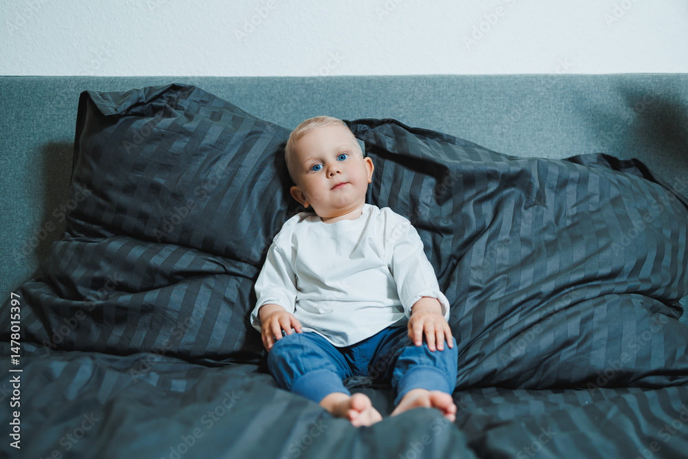 An adorable baby is peacefully relaxing on a cozy bed that is surrounded by soft and fluffy pillows, creating a serene and comforting environment perfect for a happy and carefree time