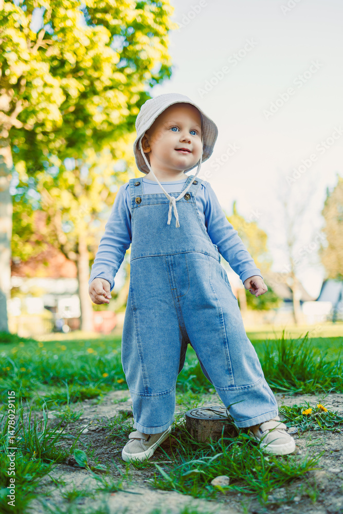 On a sunny day, a cheerful toddler in stylish overalls explores nature, plays with family, and creates unforgettable moments filled with laughter, ensuring treasured memories together