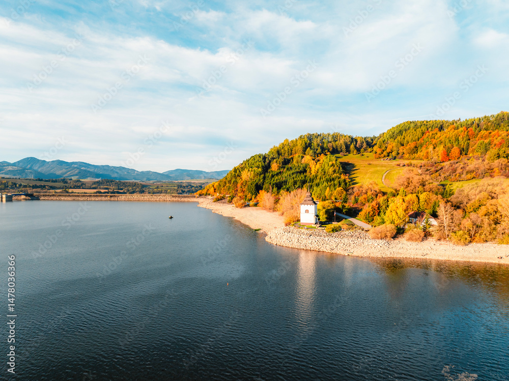 Liptov region with Tatras mountains around. Liptovska mara dam landspace. Autumn deciduous forest view from above