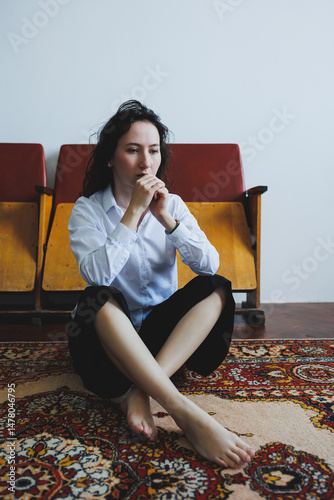 Obraz na płótnie A Thoughtful Woman, Deep in Contemplation, Sits Comfy and Barefoot on a Beautiful Vintage Rug in a Cozy Minimalist Room, Surrounded by Daylight and Intimate Decor, Evoking Reflection and Serenity w salonie