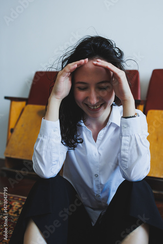 A Joyful Young Woman dressed in Smart and Stylish Attire is found Relaxing in the Comfort of Her Home, embodying a blissful and carefree lifestyle that radiates elegance and contentment