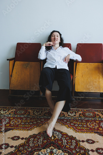 Obraz na płótnie Relaxed Woman in Stylish Attire Posing Comfortably on Vintage Chairs in Cozy Indoor Setting w salonie