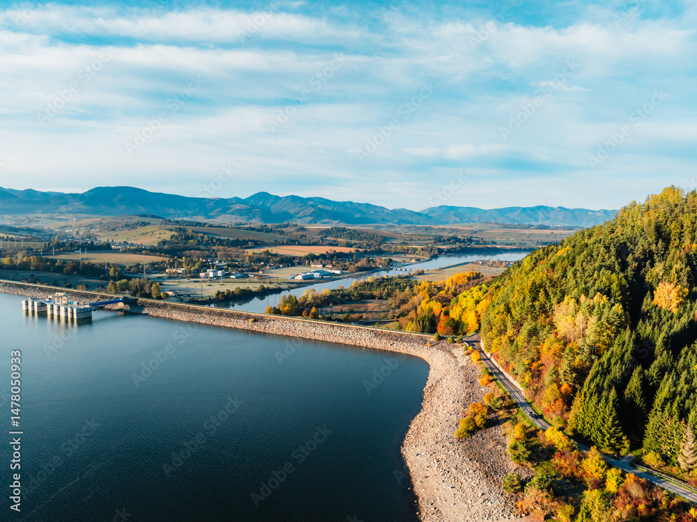 Liptov region with Tatras mountains around. Liptovska mara dam landspace. Autumn deciduous forest view from above