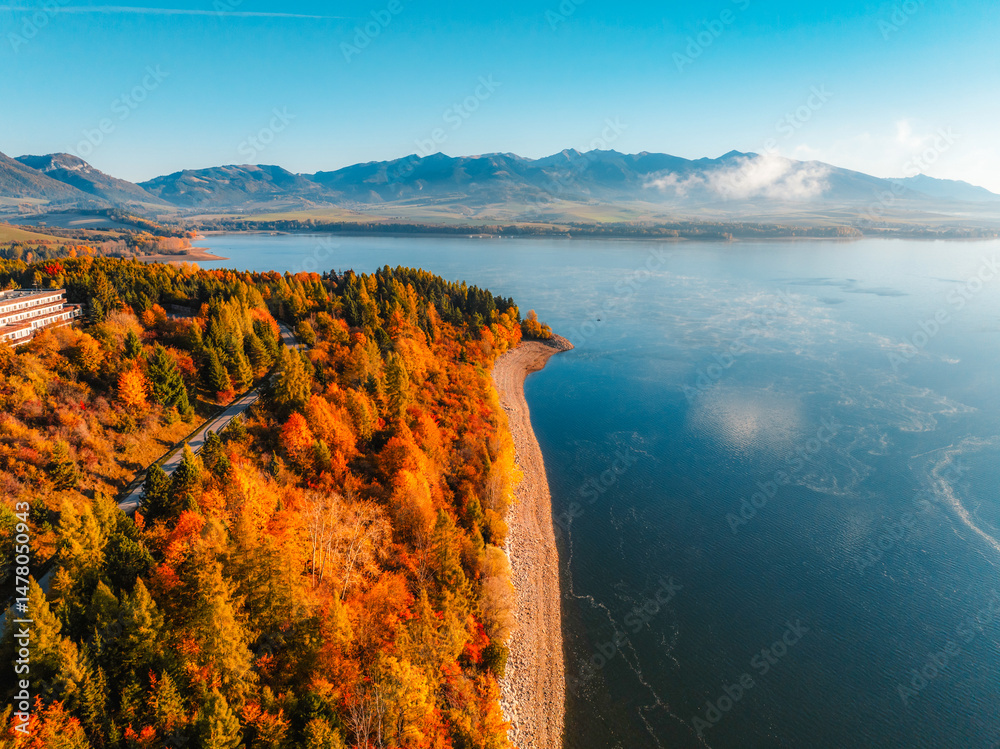Liptov region with Tatras mountains around. Liptovska mara dam landspace. Autumn deciduous forest view from above