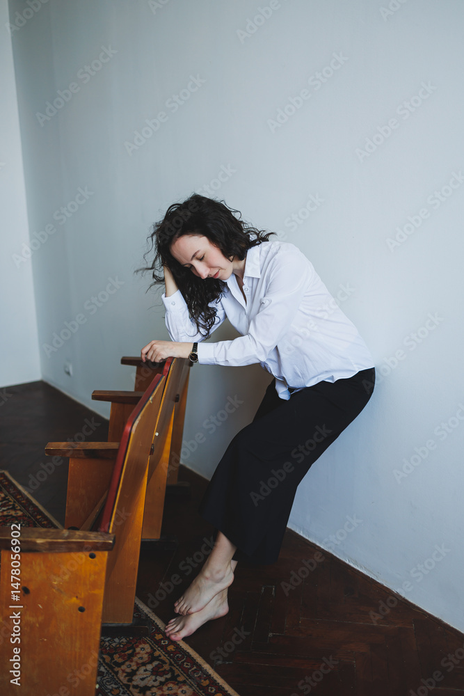 This artwork presents a contemporary portrait of a young woman situated in a relaxed pose, deeply reflecting within a serene and minimalist setting that emphasizes her calm nature and inner beauty