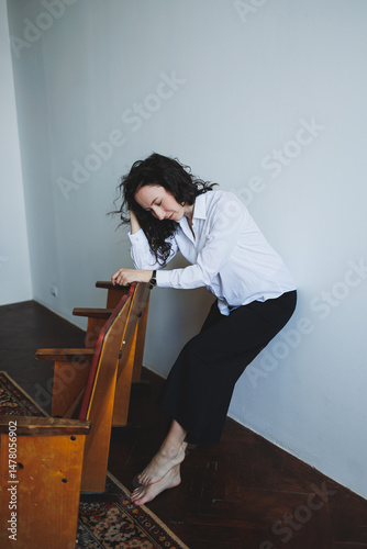 Obraz na płótnie This artwork presents a contemporary portrait of a young woman situated in a relaxed pose, deeply reflecting within a serene and minimalist setting that emphasizes her calm nature and inner beauty w salonie