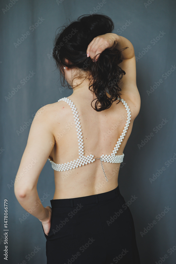 An Elegant Back View of a Beautiful Woman in Stylish Lingerie, Showcasing a Unique and EyeCatching Checkered Design Against a Sophisticated Gray Background to Highlight Her Graceful Figure