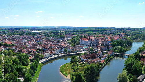 Eine beeindruckende Luftaufnahme von Neuburg an der Donau, einer malerischen Stadt in Bayern, Deutschland. Die Donau schlängelt sich durch die Stadt und bildet eine kleine Insel. photo