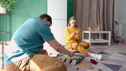 Beautiful young couple having fun playing board game while relaxing and enjoying leisure time together at home