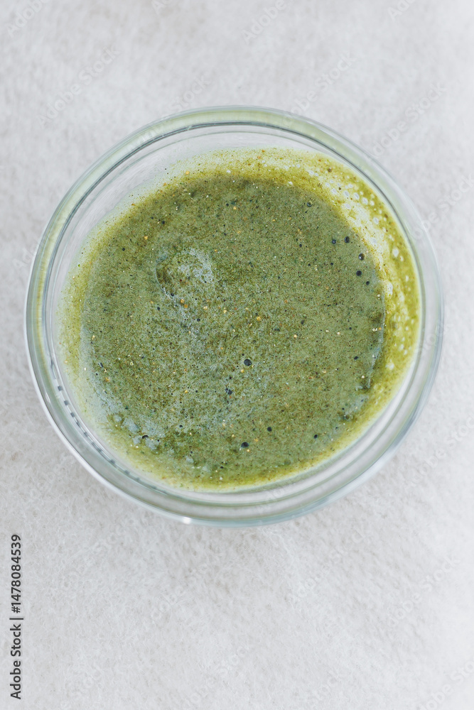 A Fresh Green Herbal Sauce beautifully packaged in a sleek Glass Container This capsulated flavor is sure to be a Vibrant Addition to All Your Culinary Creations and meal presentations
