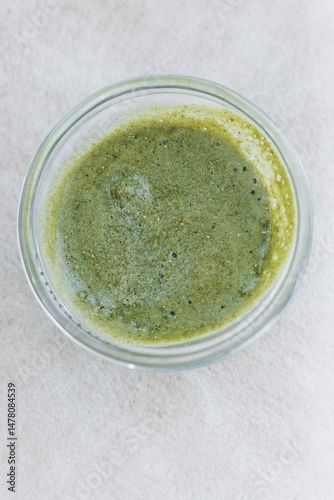 Obraz na płótnie A Fresh Green Herbal Sauce beautifully packaged in a sleek Glass Container This capsulated flavor is sure to be a Vibrant Addition to All Your Culinary Creations and meal presentations w salonie