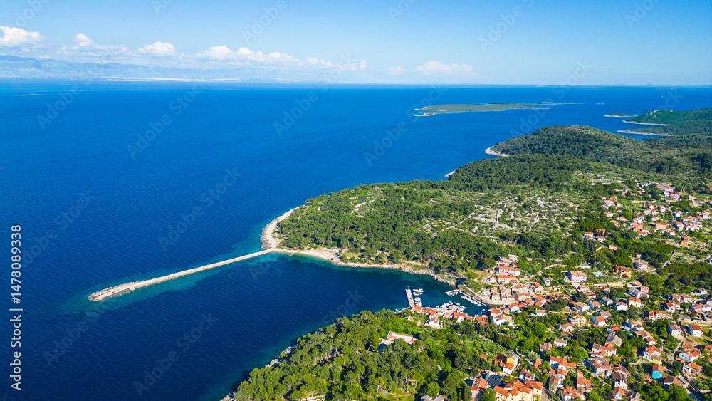 Fototapeta premium Aerial view of Veli Lošinj (Losinj), charming historic town on the island of Mali Lošinj, Croatia. Colorful old architecture, narrow streets, and crystal Adriatic waters create stunning coastal scene