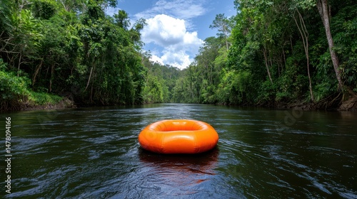 Orange tube floating on a dark river, surrounded by lush green tropical rainforest. Sunlight streams through the dense canopy above. Peaceful and serene atmosphere.
