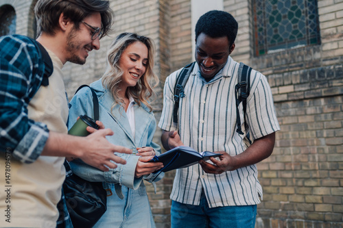 Students consulting a notebook while visiting a city