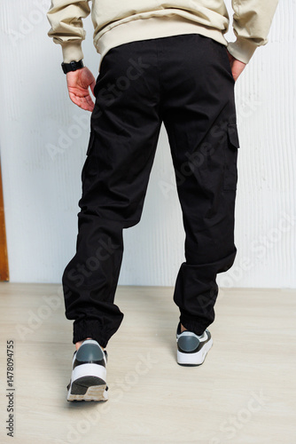 Obraz na płótnie Discover our stylish black cargo pants that feature adjustable cuffs, perfect for achieving a trendy and casual look. They are not only fashionable but also functional for everyday wear w salonie