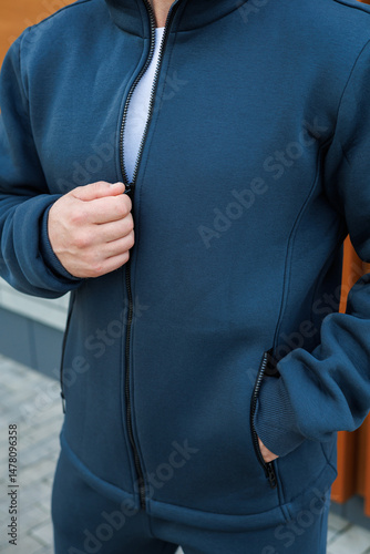 Obraz na płótnie A Stylish Man is seen in a Modern Athletic Jacket posing confidently outdoors, set against a Trendy Urban backdrop, showcasing the essence of contemporary fashion and active lifestyle w salonie