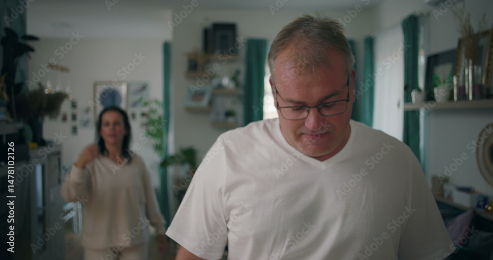 Man turning to face woman during argument in living room, couple engaging in emotional and tense dispute, focus on body language and intense communication