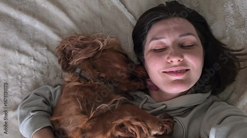 A red cocker spaniel licks his owner, demonstrating the deep bond and friendship between man and dog.