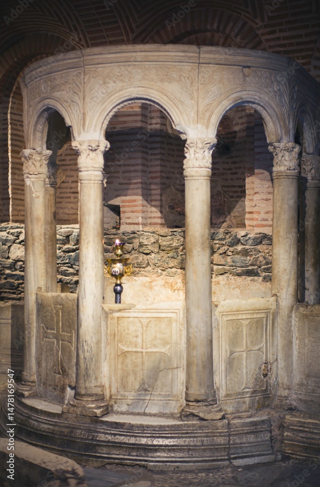 Fototapeta premium Beneath the ethereal light, intricately carved marble columns rise gracefully in a historic structure in Zakynthos, Greece. The remnants exude timeless beauty and mystery, inviting exploration