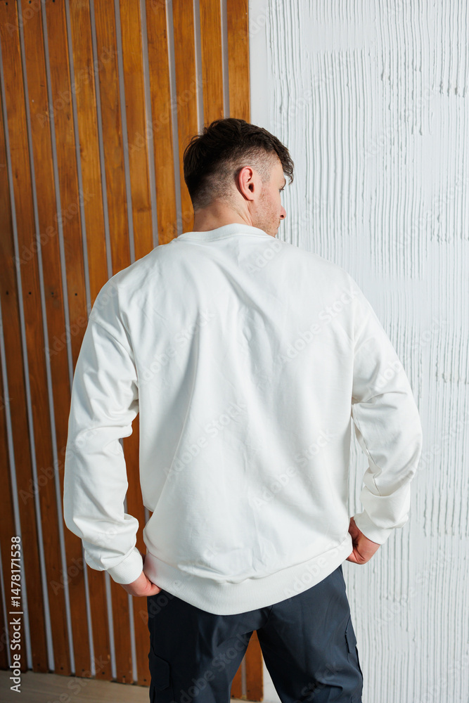 Stylish Casual Wear Captivating Back View of a Man Dressed in a Trendy White Sweatshirt Set Against a Unique and Textured Background, Perfect for Fashion and Lifestyle Photography