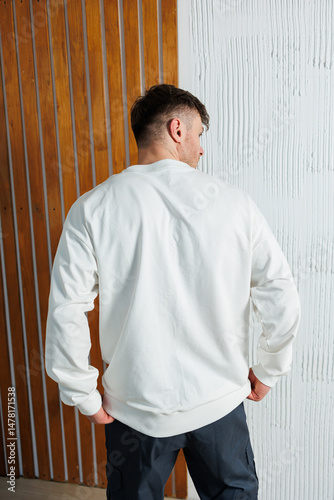 Obraz na płótnie Stylish Casual Wear Captivating Back View of a Man Dressed in a Trendy White Sweatshirt Set Against a Unique and Textured Background, Perfect for Fashion and Lifestyle Photography w salonie