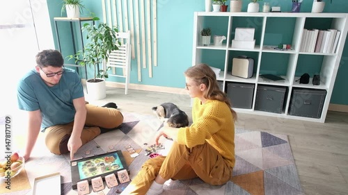 Beautiful young couple having fun playing board game while relaxing and enjoying leisure time together at home