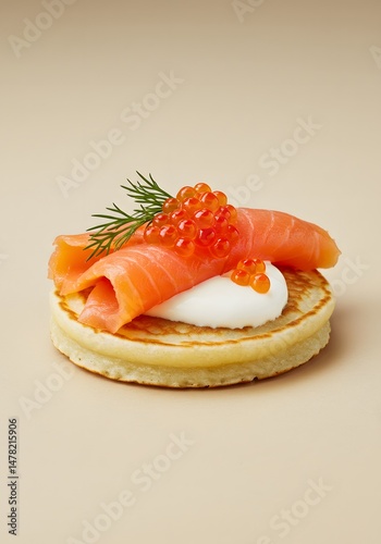A delightful single blini appetizer with smoked salmon, roe, and cream cheese on a neutral background.