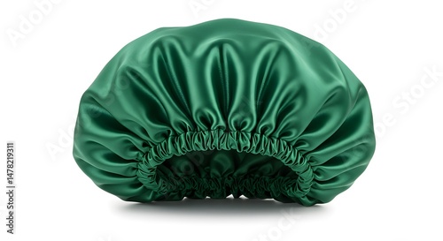 Elegant, glossy green satin bonnet resting on a white surface, perfect for hair protection.