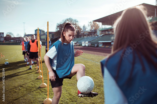 Female soccer players training with passing drills on outdoor field
