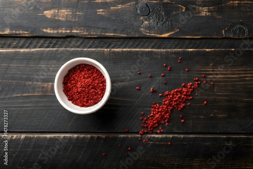 Annatto Seeds in White Bowl on Wooden Surface – Natural Culinary Coloring Ingredient