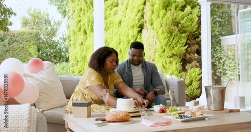 Enjoying outdoor brunch, mature couple sharing laughter and conversation on patio