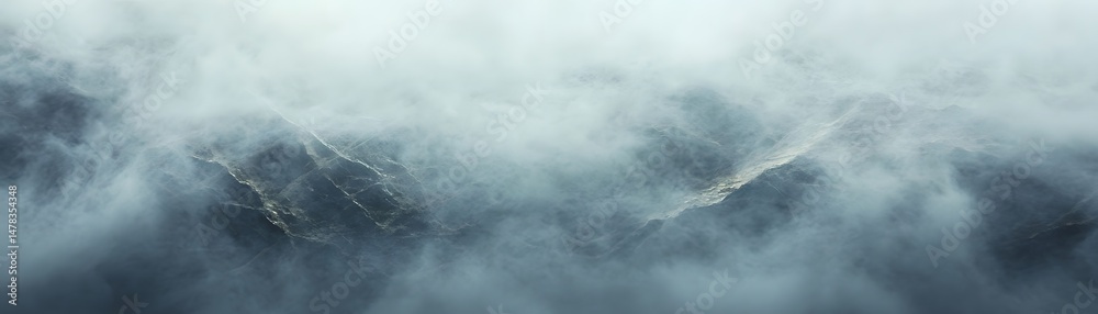 Obraz premium High-altitude view of a misty mountain range.