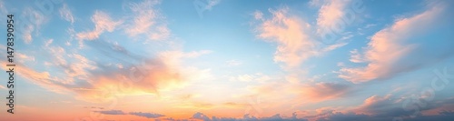Vibrant sunset sky with soft pastel colors blending from orange to blue and scattered clouds creating a peaceful atmosphere