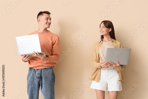 Young couple using laptops ...