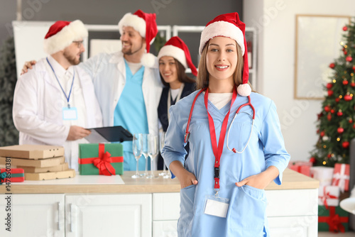 Female doctor in Santa hat ...
