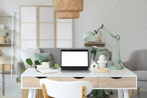 Blank laptop with lamp on p...
