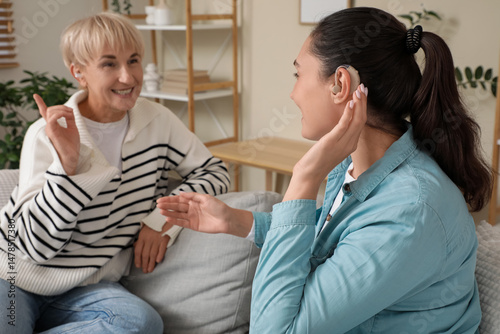 Women with hearing aids sit...