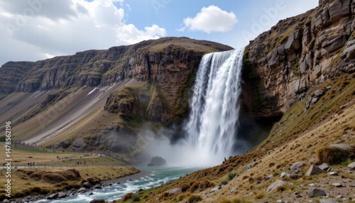Stunning waterfall cascades down rocky cliffs, surrounded by lush greenery and rugged terrain. scene captures beauty of nature, with vibrant sky and mist rising from water