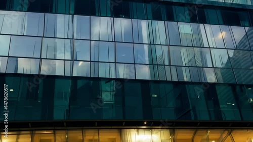 Reflective glass facade of a modern building under clear sky, capturing urban architecture and clean contemporary design elements. photo