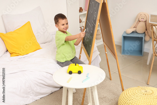 Cute little boy drawing on ...