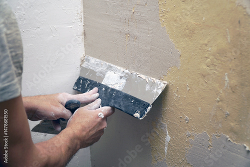 A man plastering a wall with a spatula