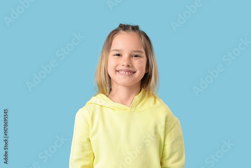 Little girl smiling on blue...