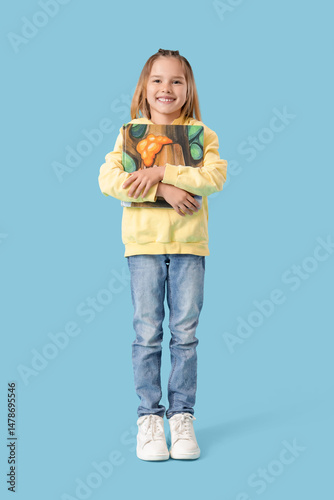 Little girl with book on blue background