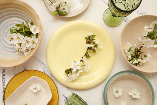 Different clean plates with blooming branches on white background