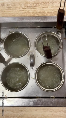 Boiling hot water in a noodle cooking place made of stainless steel, the process of boiling noodles using a round tool in a restaurant kitchen