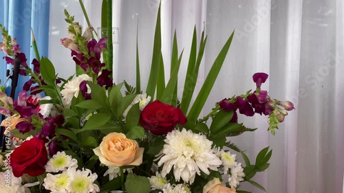 Colorful Flower Arrangement with various flowers in various colors. luxurious decorative flower arrangement with wavy fabric curtain background