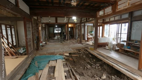 Demolished traditional house interior shows exposed floorboards and supports during renovation project in an old home