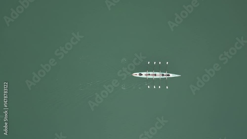 Sport Canoe with a team of four people rowing on tranquil water, Aerial view. High quality 4k footage
