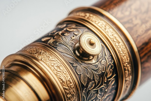 Close-up of an ornate antique brass telescope with intricate floral engravings and a focus knob.
