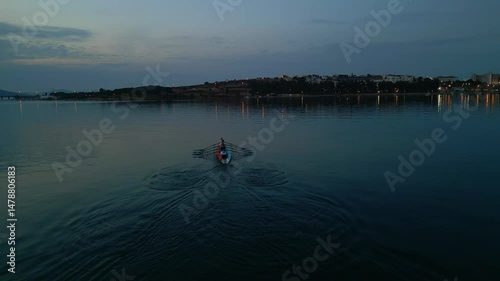 Sport Canoe with a team of four people rowing on tranquil water, Aerial view. High quality 4k footage
